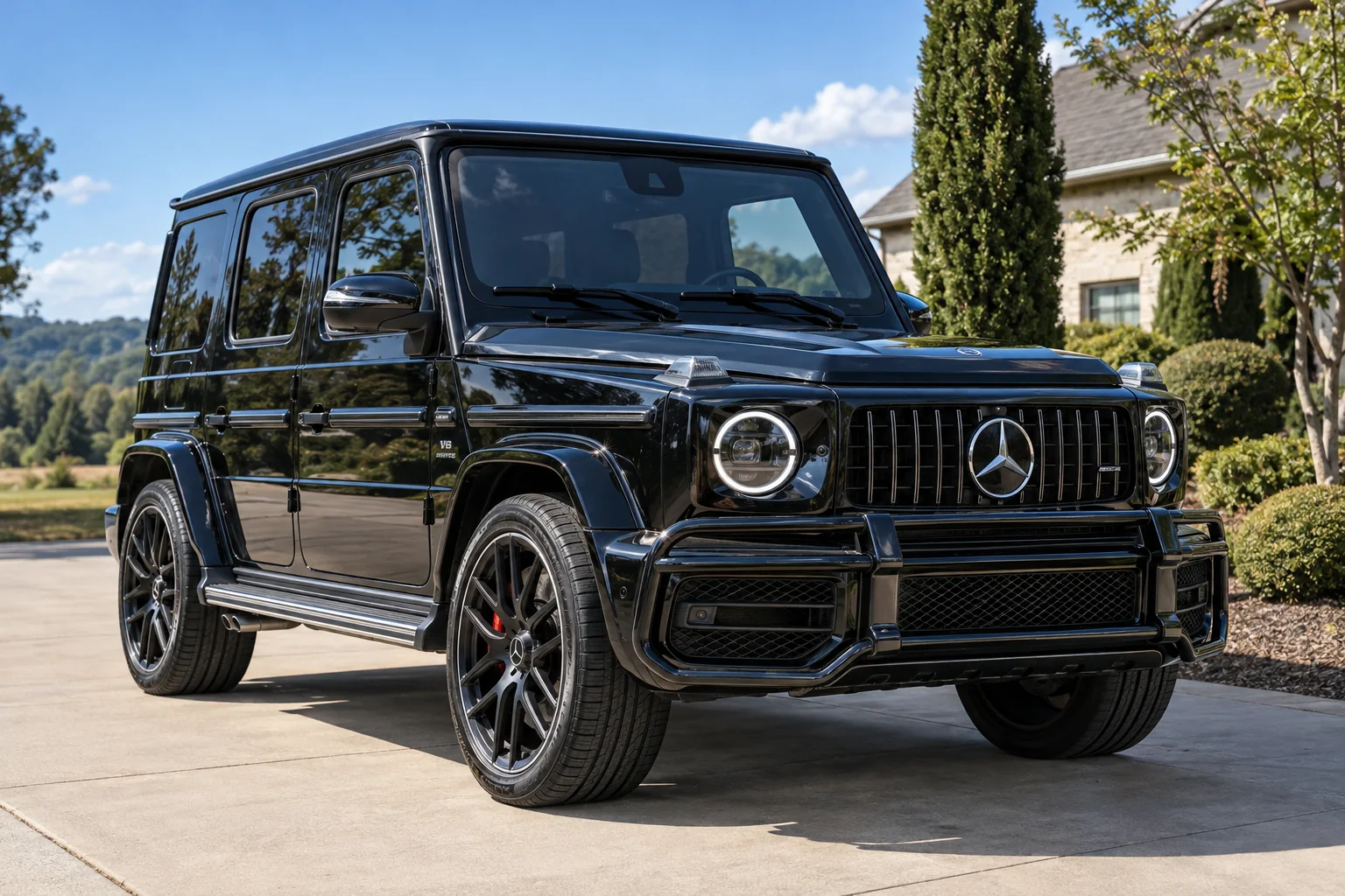 A black Mercedes G-Class with tinted windows on a driveway