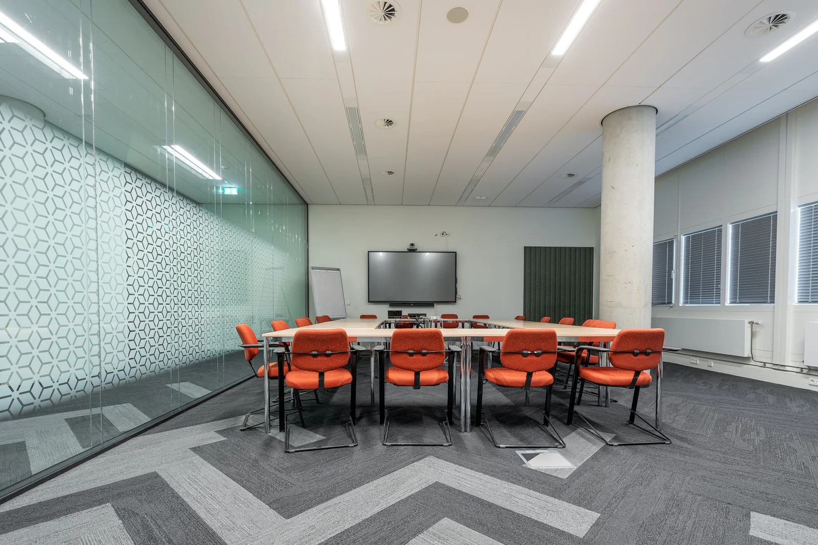 A meeting room behind a glass wall with a frosted pattern